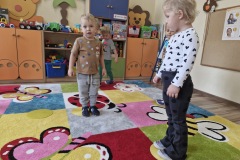 Dzieci stoją na plastikowych dużych kropkach.