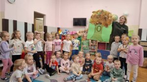 Dzieci z grup Biedronki, Motylki i Zajączki pozują do wspólnego zdjęcia z panią Olą Kołacz.