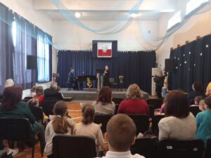 Uczeń szkoły Muzycznej gra na ciekawym instrumencie przy akompaniamencie nauczyciela.